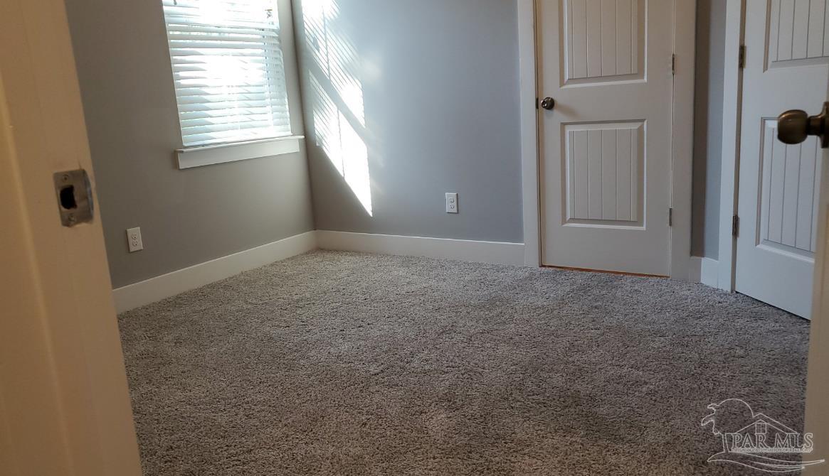 9822 Utopia Drive, Unit E Pensacola, FL 32514 - Photo 7 of 13 an empty room with windows