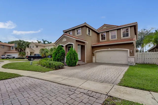 a front view of a house with a yard and garage