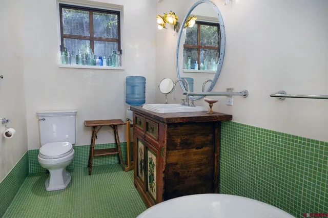 a bathroom with a toilet a sink and mirror