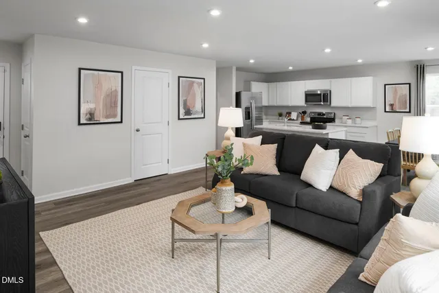 a living room with stainless steel appliances kitchen island furniture and a view of kitchen