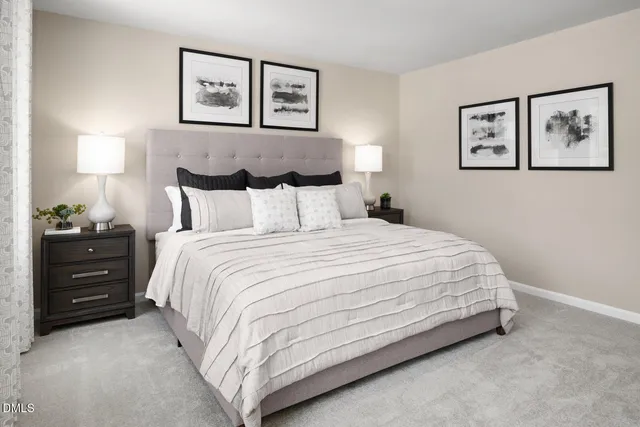 a bedroom with a bed and a lamp on dresser