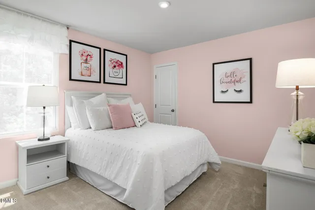 a bedroom with bed and paintings on the wall