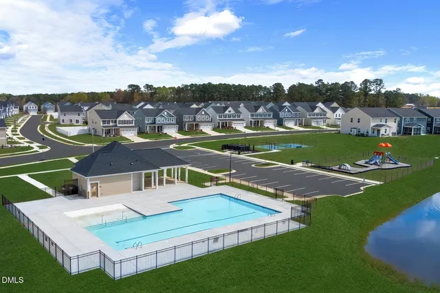 an aerial view of residential houses with outdoor space and trees