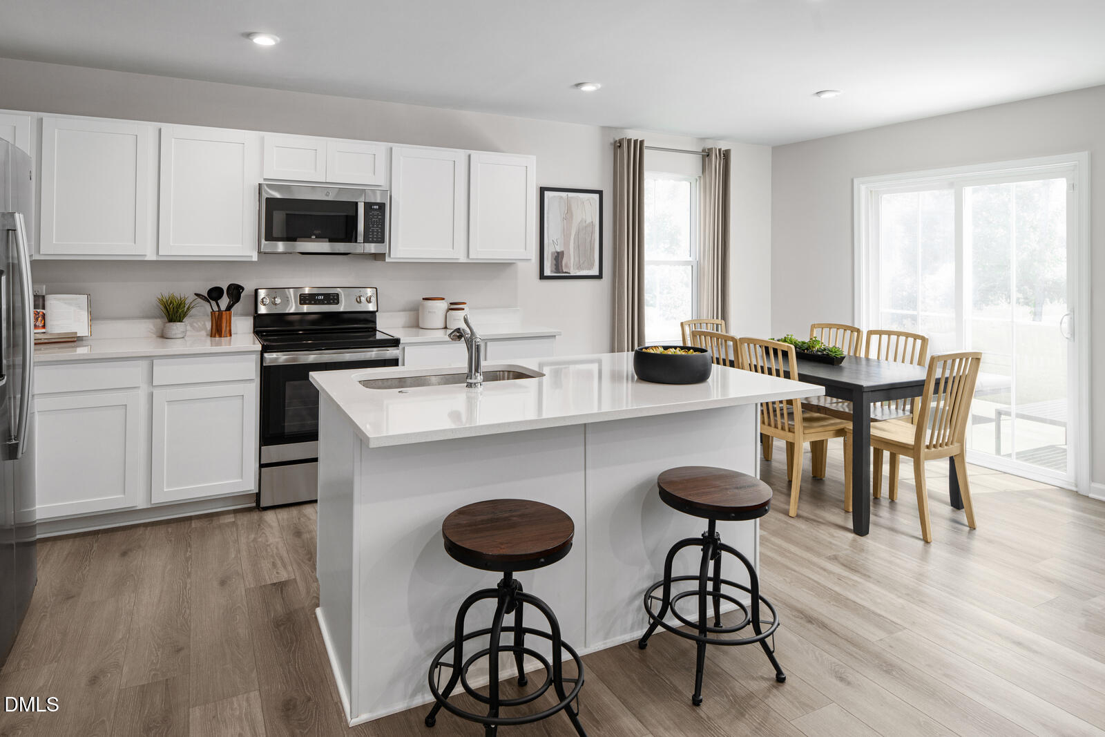 132 Cavalier Rider Run Wendell, NC 27591 - Photo 2 of 24 a kitchen with stainless steel appliances granite countertop a stove a sink a microwave a dining table and chairs with wooden floor