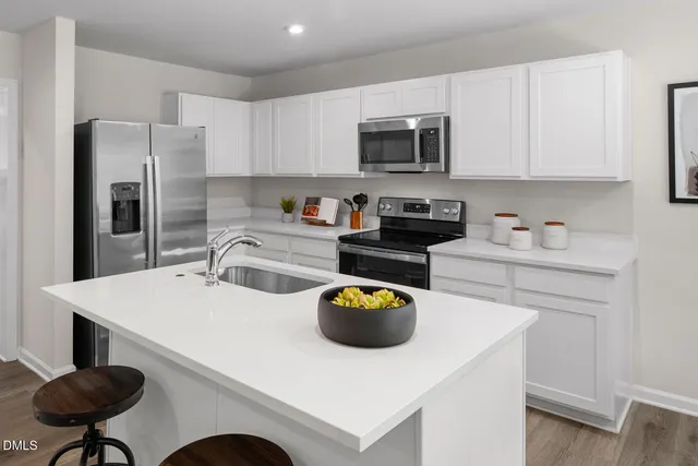a kitchen with stainless steel appliances a stove a sink a microwave and cabinets