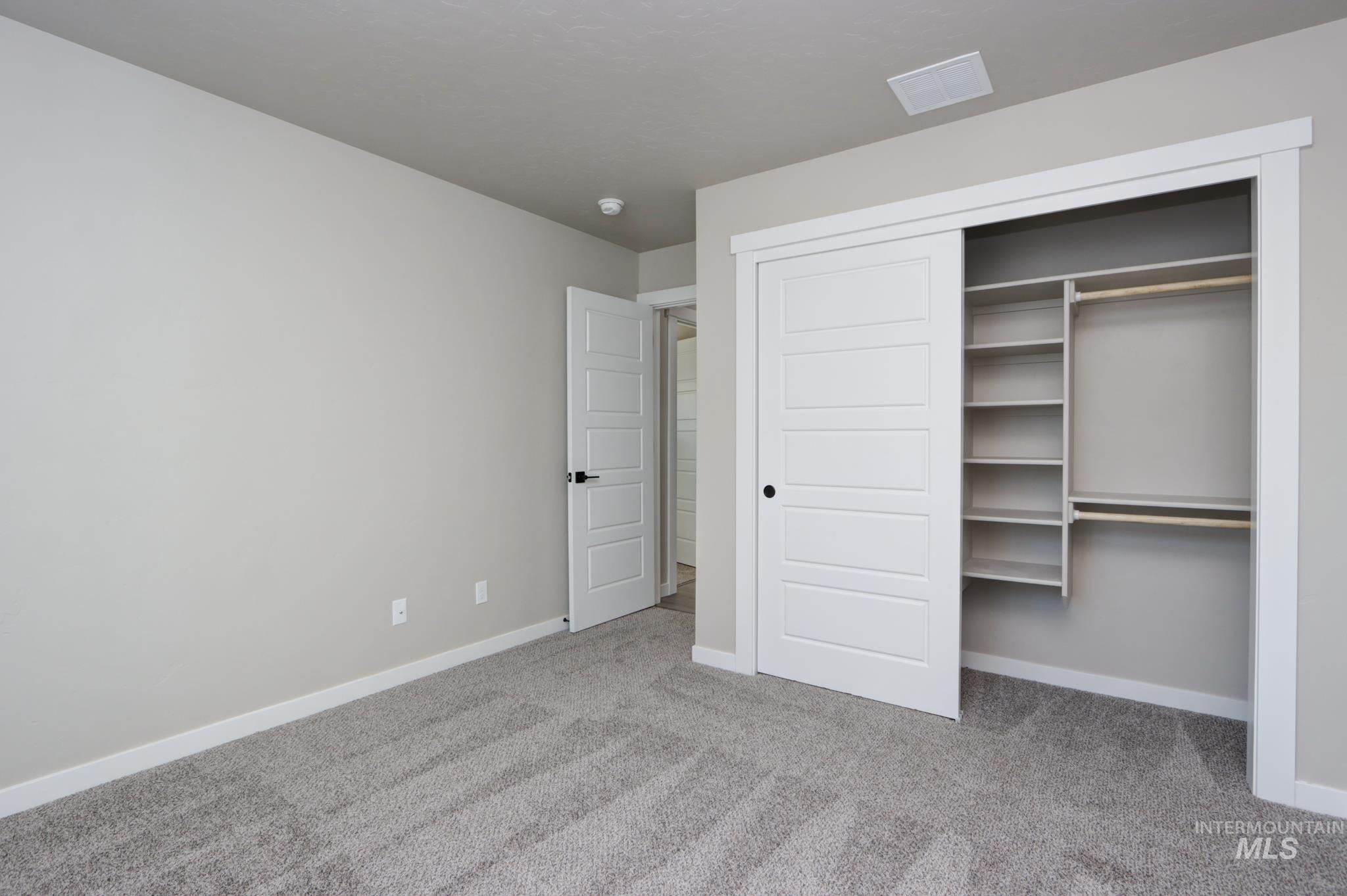 848 North 5th Street Nyssa, OR 97913 - Photo 36 of 49 Carpeted room featuring a built-in closet with sliding panel doors, integrated shelving, and hanging rods