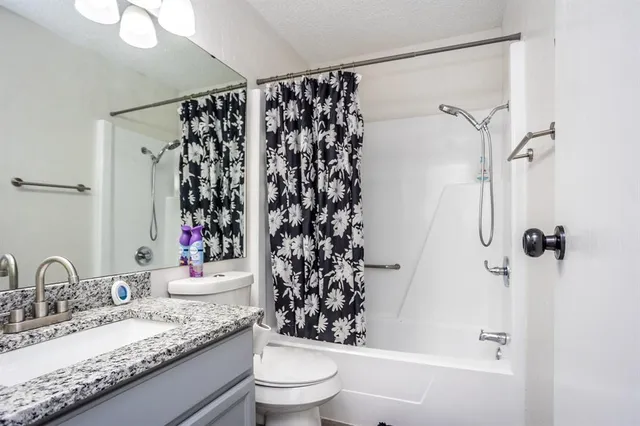a bathroom with a granite countertop sink toilet and shower