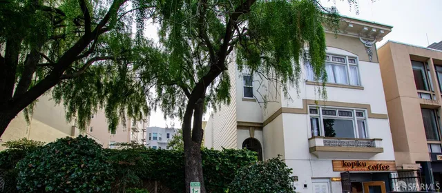 a view of white house with a palm tree