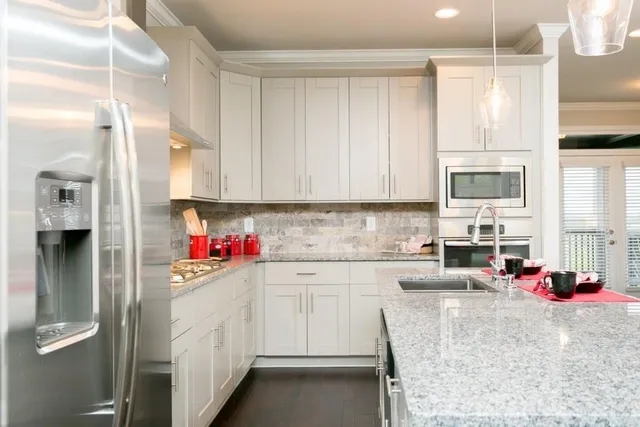 a kitchen with granite countertop white cabinets and a window