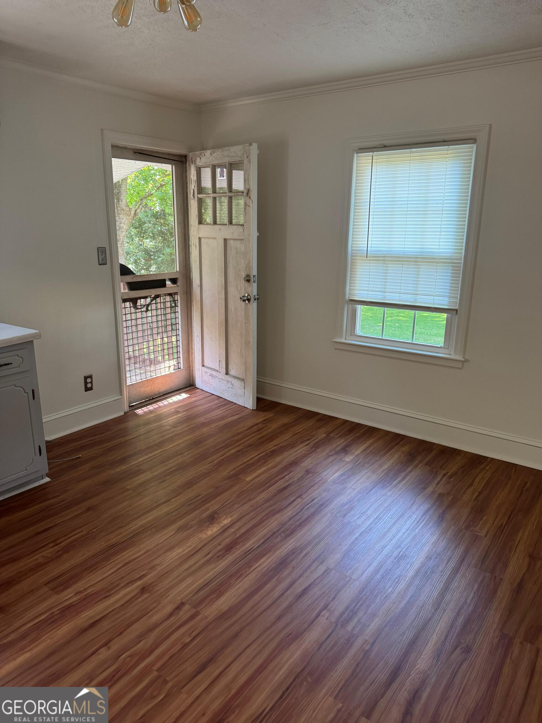 609 West Main Street Thomaston, GA 30286 - Photo 13 of 27 an empty room with wooden floor and windows