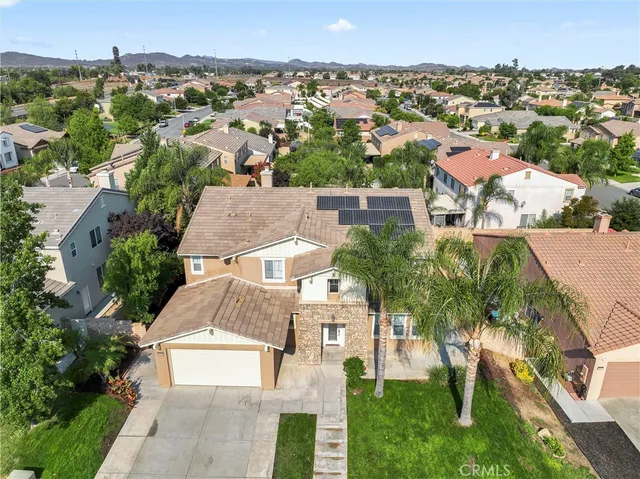an aerial view of residential houses with outdoor space and trees