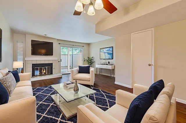 a living room with furniture a flat screen tv and a fireplace