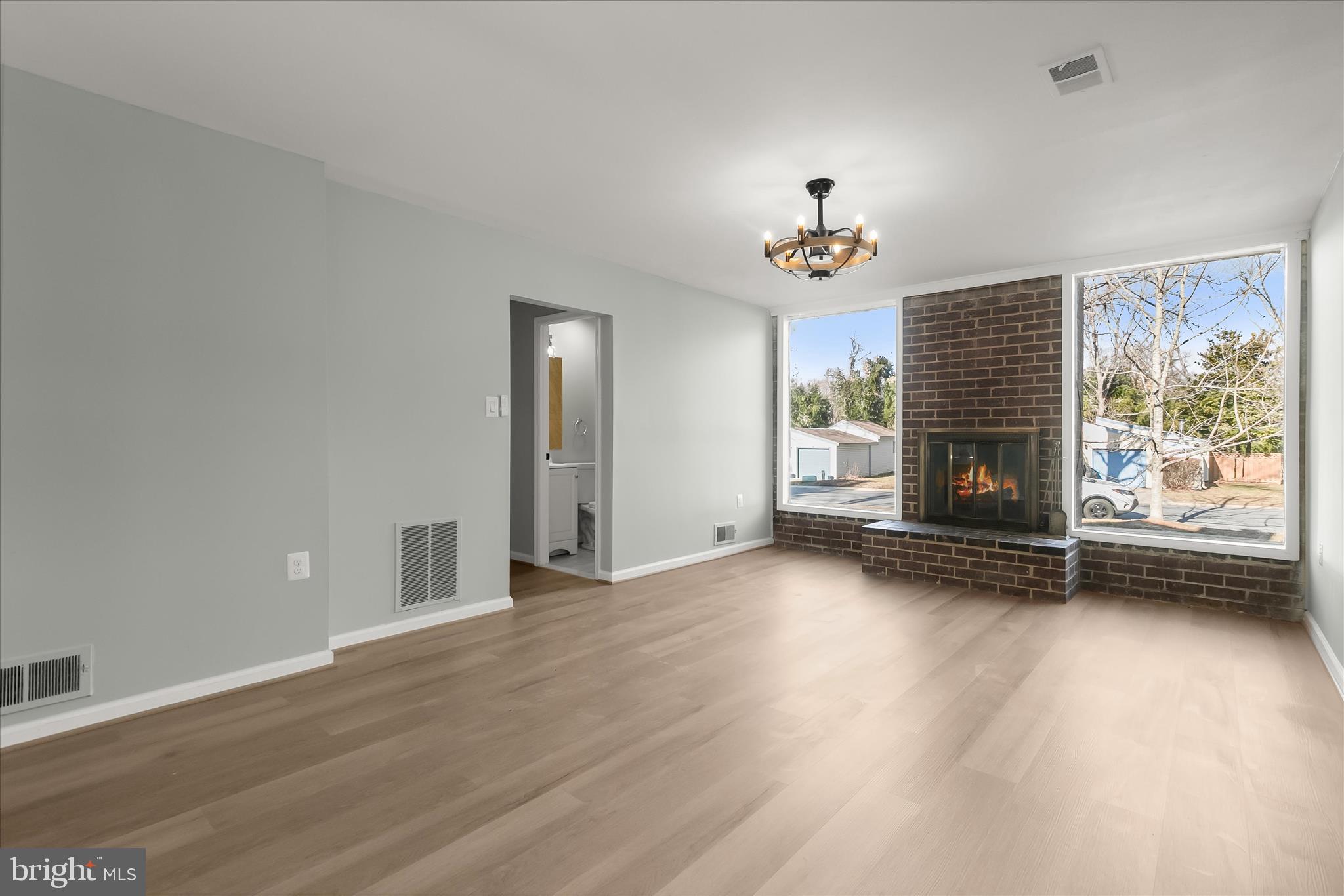 9511 Wandering Way Columbia, MD 21045 - Photo 27 of 62 an empty room with wooden floor fireplace and windows