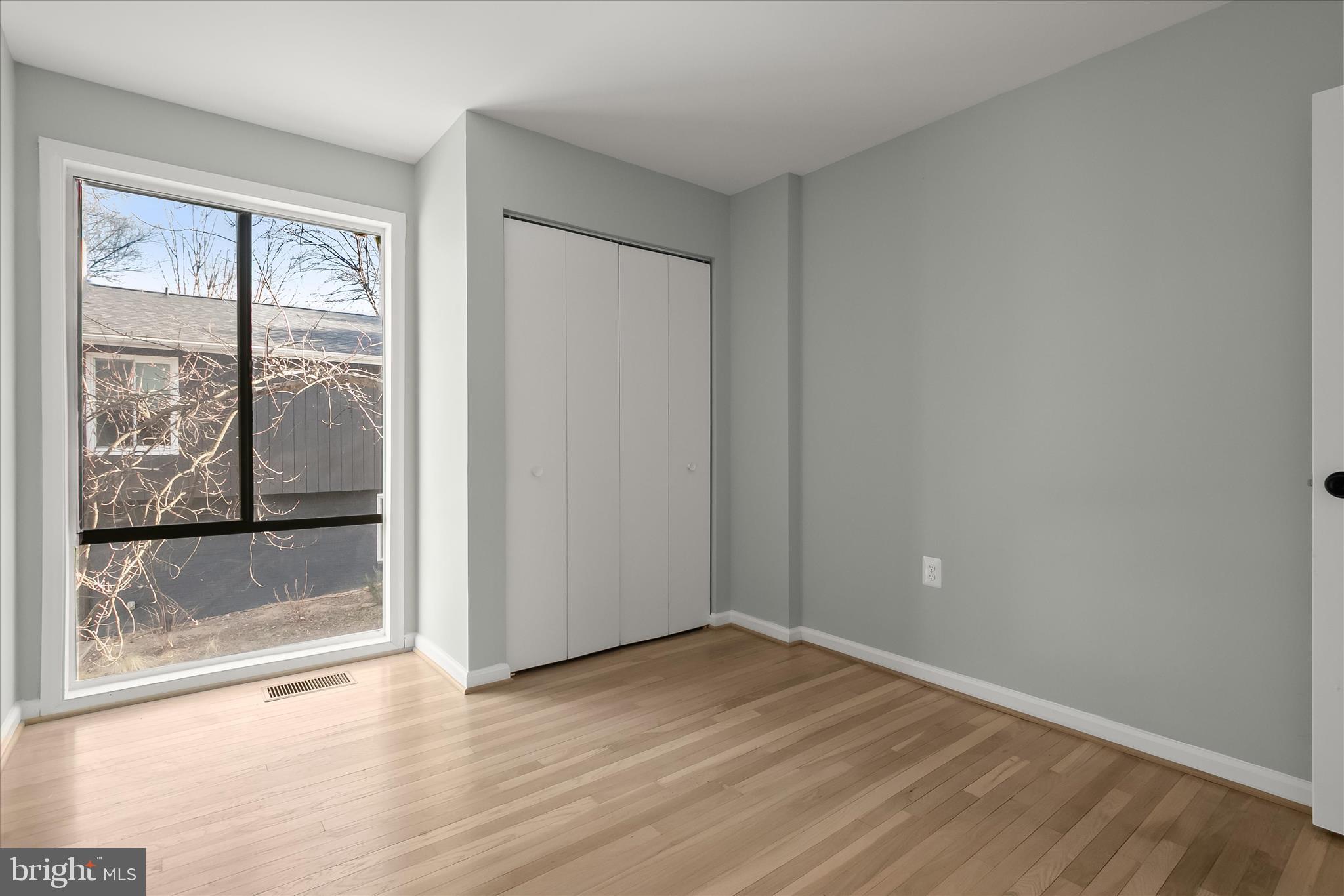 9511 Wandering Way Columbia, MD 21045 - Photo 45 of 62 an empty room with wooden floor and windows