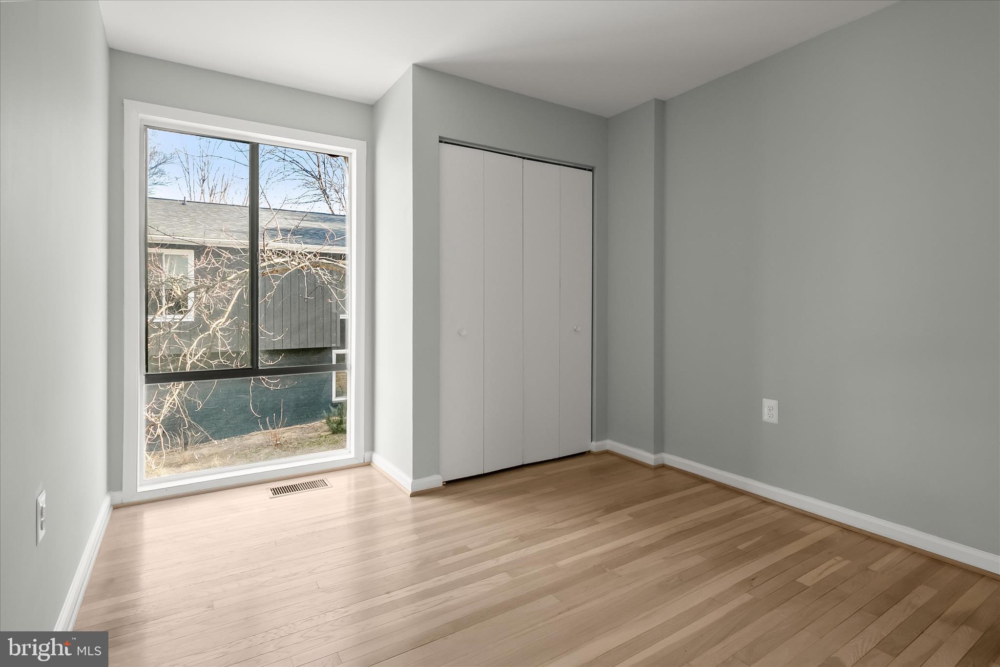 9511 Wandering Way Columbia, MD 21045 - Photo 46 of 62 an empty room with wooden floor and windows