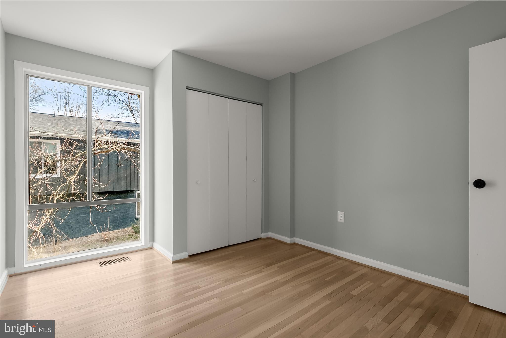 9511 Wandering Way Columbia, MD 21045 - Photo 47 of 62 a view of an empty room with wooden floor and a window