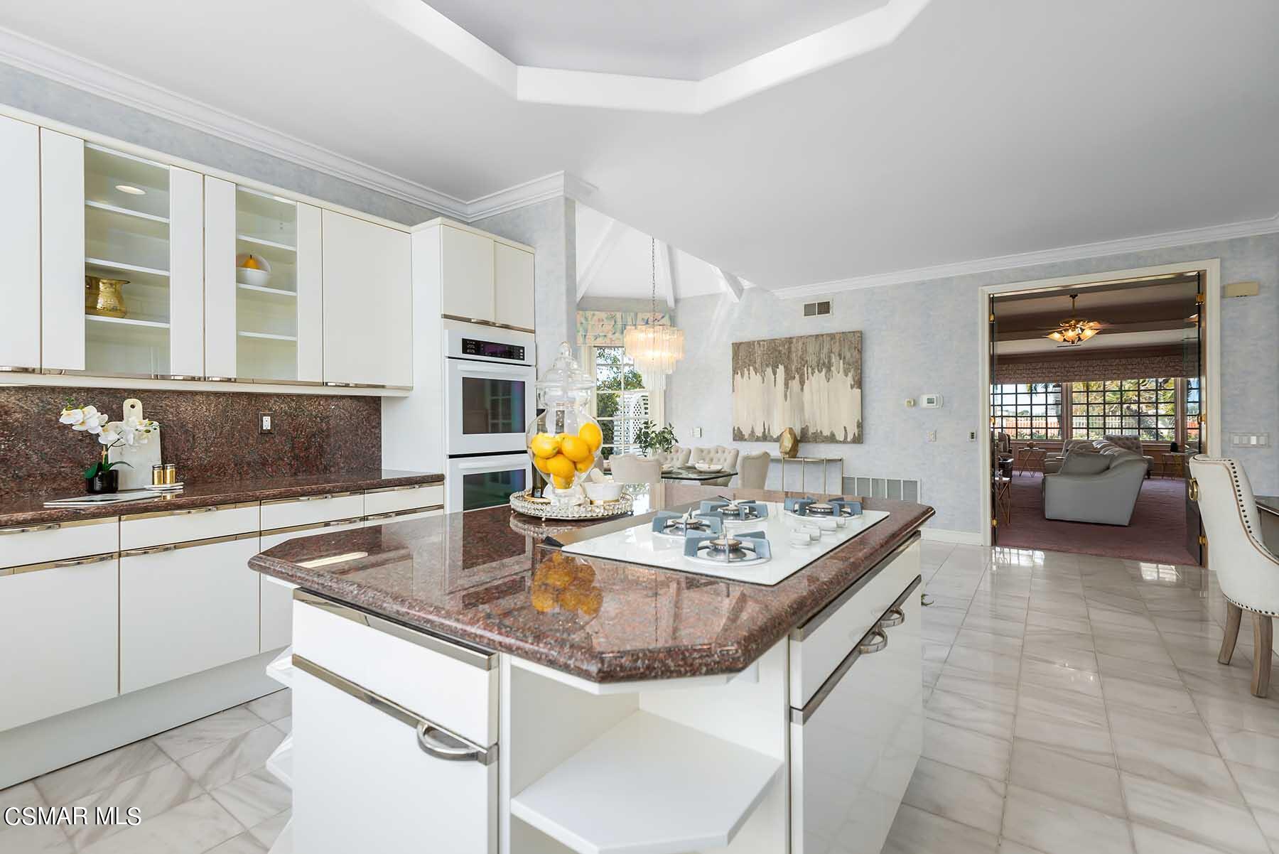 5467 Wellesley Drive Calabasas, CA 91302 - Photo 13 of 60 a kitchen with a stove a sink a dining table and chairs