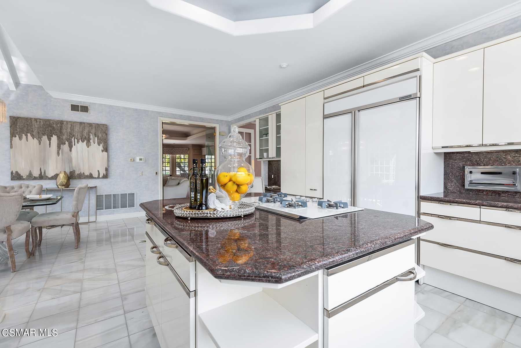 5467 Wellesley Drive Calabasas, CA 91302 - Photo 14 of 60 a kitchen with kitchen island granite countertop a sink a counter top space and living room area