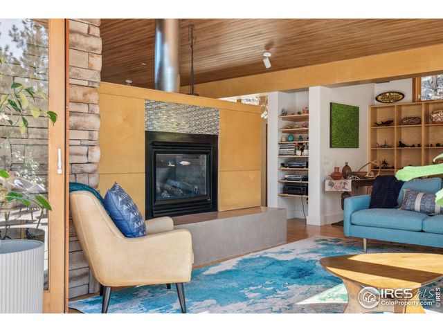 a living room with furniture a flat screen tv and a large window