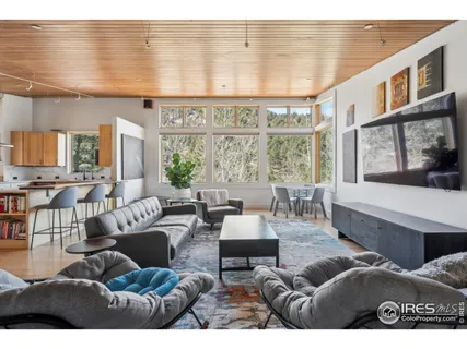 a living room with furniture a flat screen tv and a large window