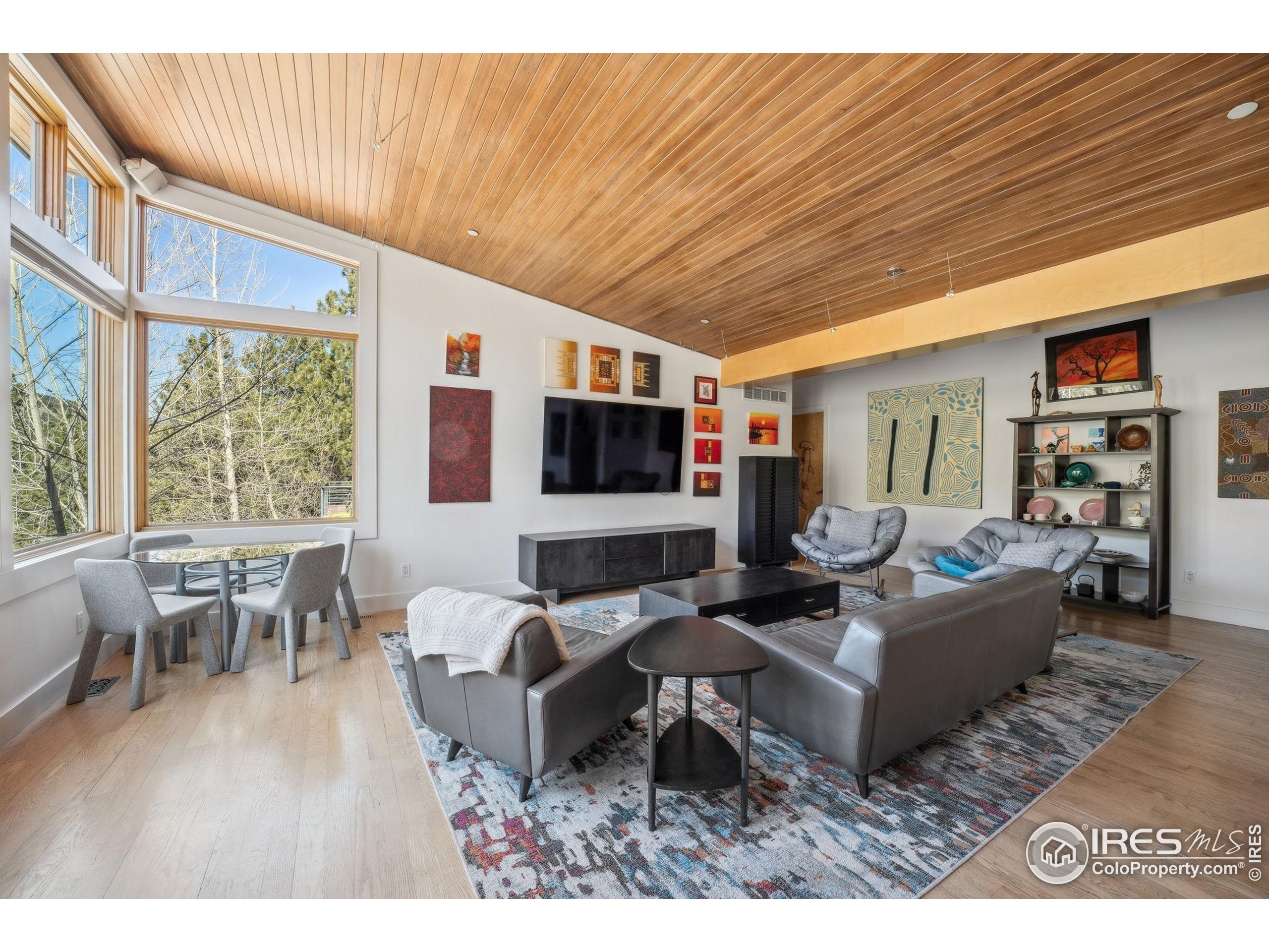 1127 Valley Lane Boulder, CO 80302 - Photo 19 of 48 a living room with furniture a flat screen tv and a large window