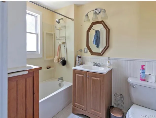 a bathroom with a sink mirror bathtub and toilet
