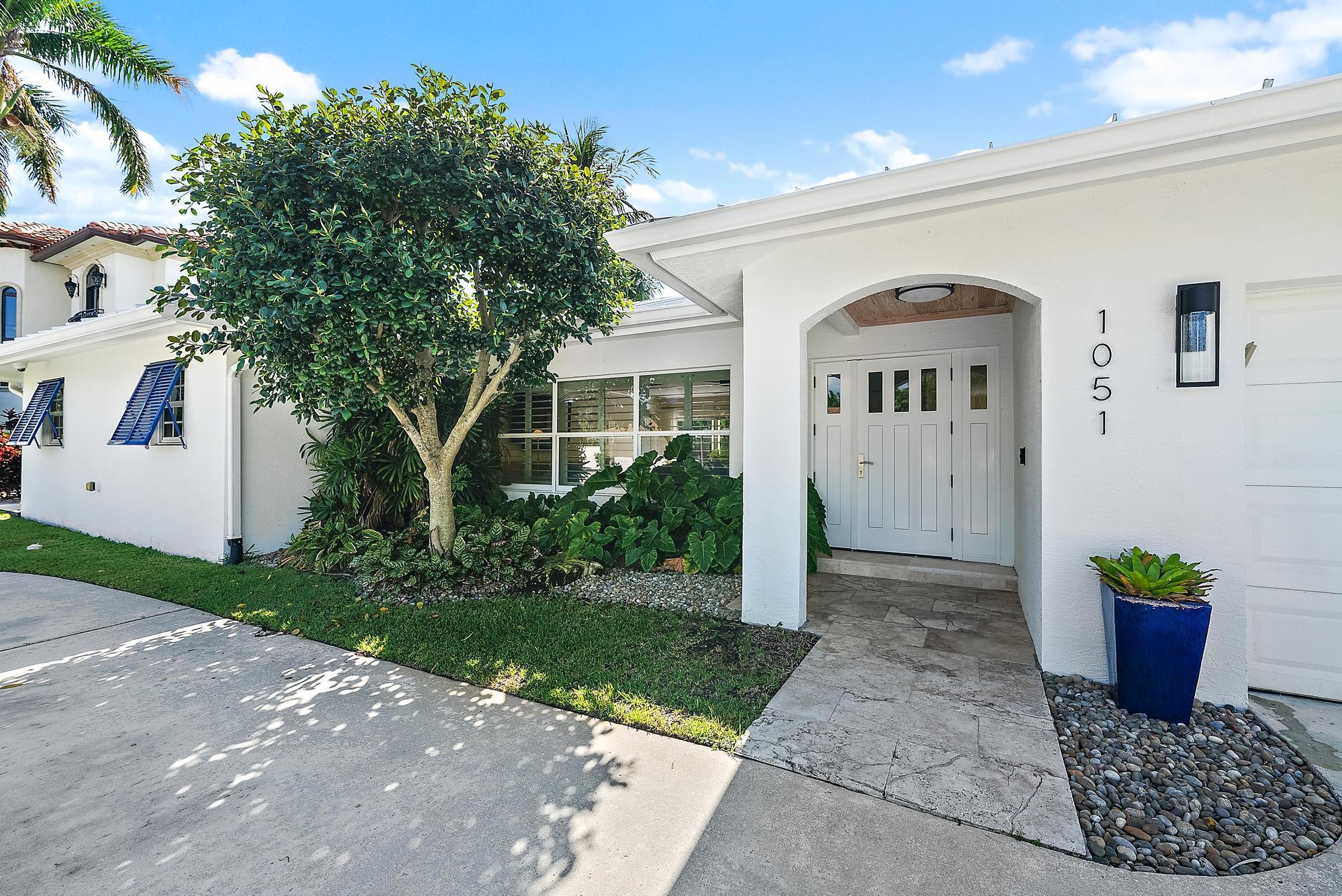 1051 Gulfstream Way Singer Island, FL 33404 - Photo 2 of 49 a front view of a house with a porch