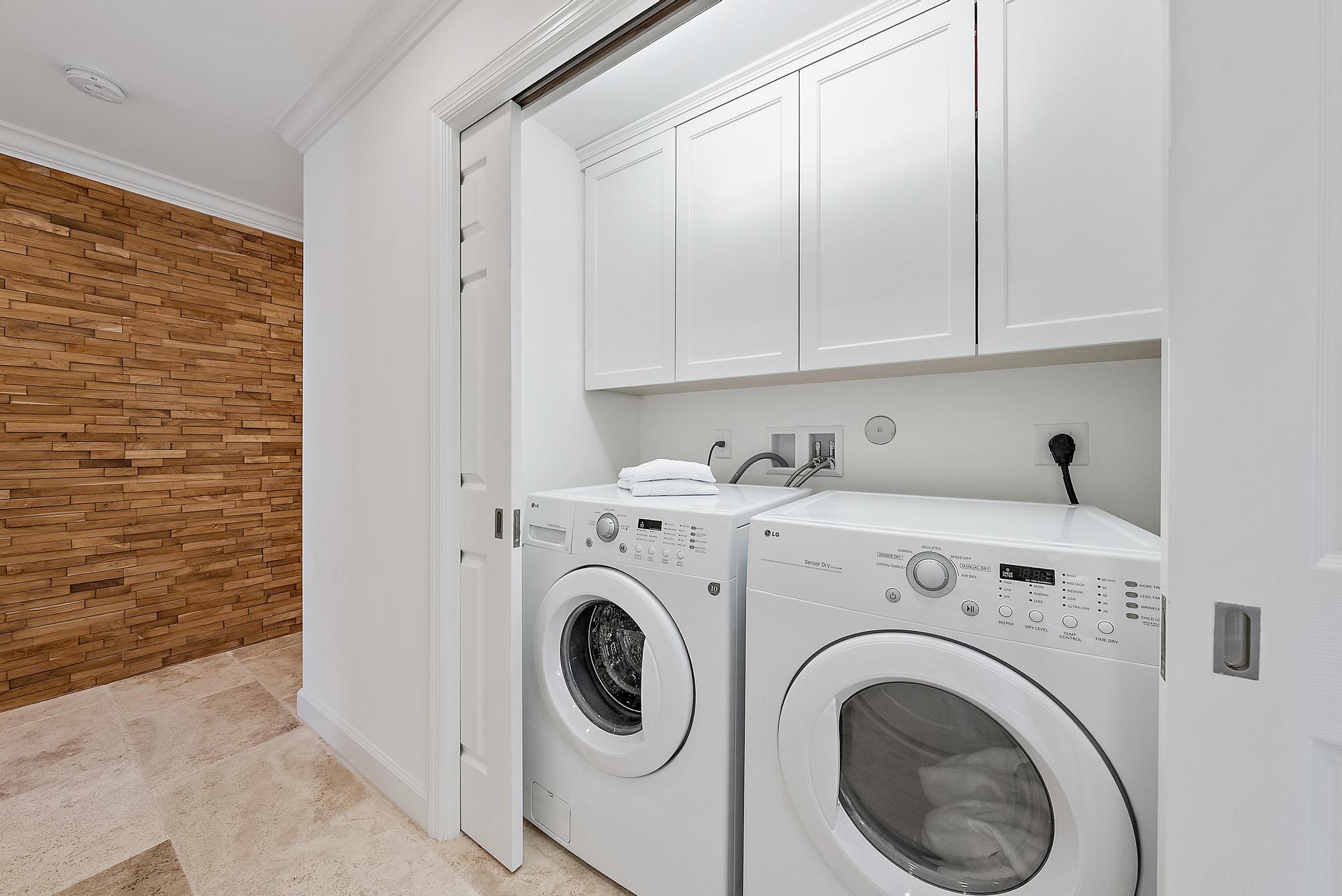 1051 Gulfstream Way Singer Island, FL 33404 - Photo 24 of 49 a view of washer and dryer with kitchen in the background