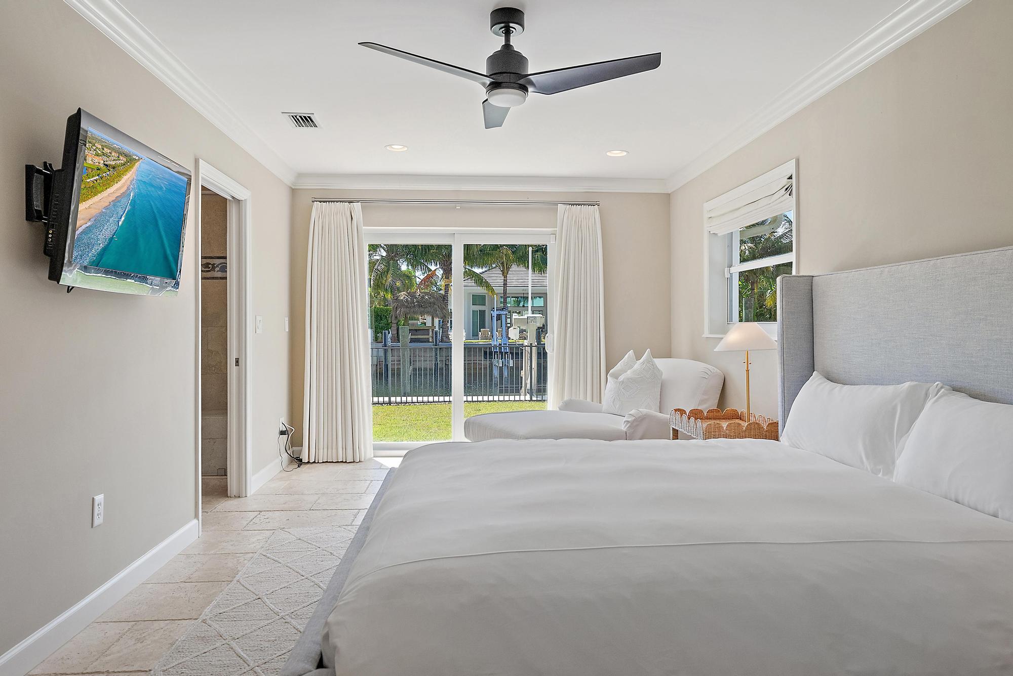 1051 Gulfstream Way Singer Island, FL 33404 - Photo 28 of 49 a bedroom with a bed and a flat screen tv