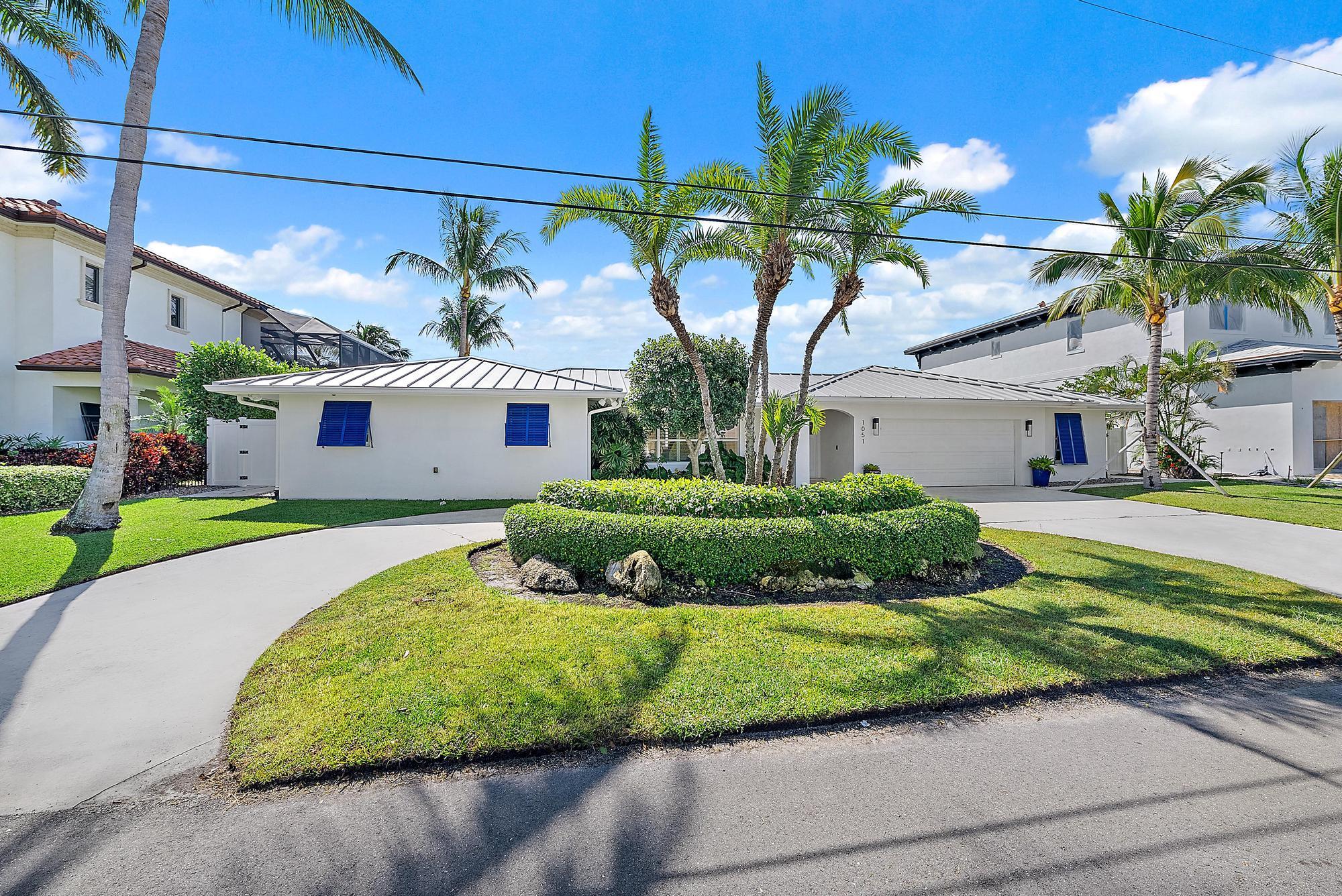 1051 Gulfstream Way Singer Island, FL 33404 - Photo 3 of 49 a view of a white house with a big yard and potted plants