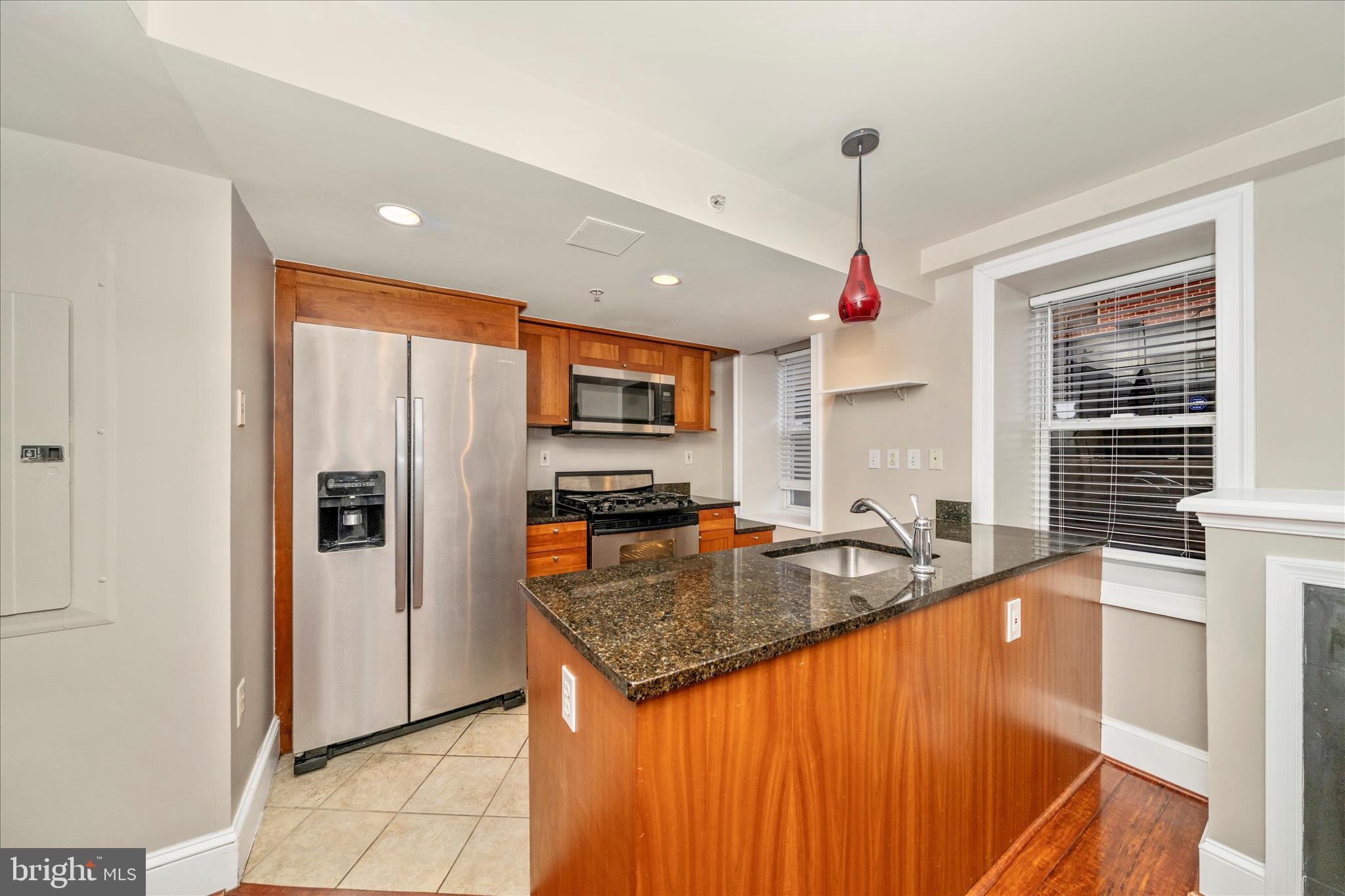 1750 16th Street Northwest, Unit 4 Washington, DC 20009 - Photo 11 of 53 a kitchen with granite countertop a sink refrigerator and microwave