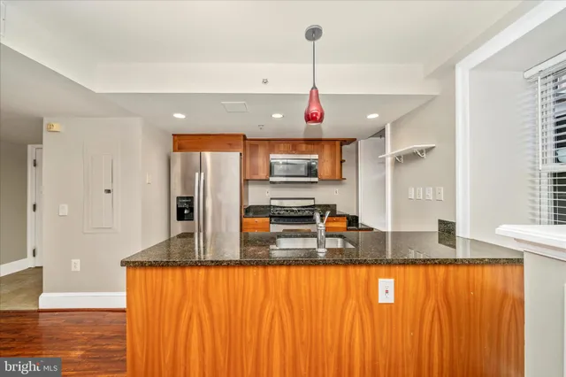 a kitchen with stainless steel appliances granite countertop a refrigerator a sink and a granite counter tops