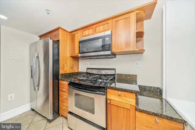 a kitchen with granite countertop cabinets stainless steel appliances and a counter top space