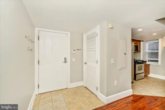 a view of a kitchen with refrigerator and wooden floor