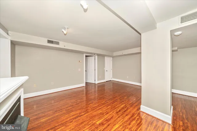 a view of an empty room with wooden floor