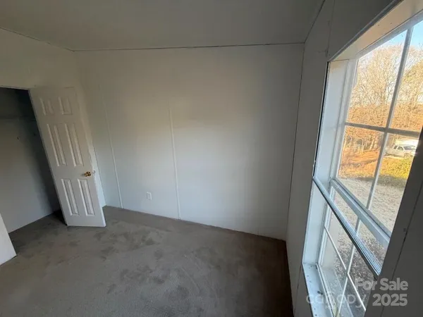 a bathroom with a sink a mirror a toilet and a window