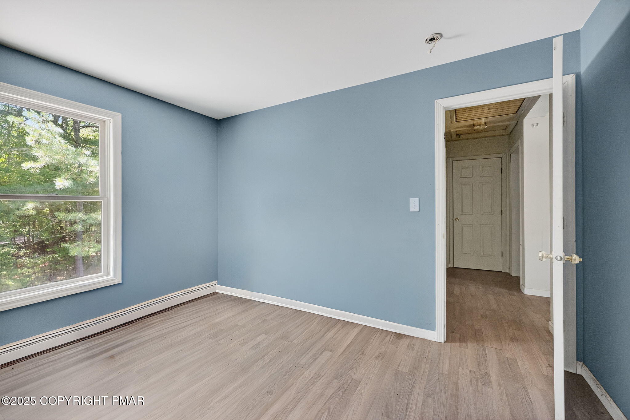 375 Marcel Drive Dingmans Ferry, PA 18328 - Photo 11 of 25 a view of an empty room with wooden floor and a window