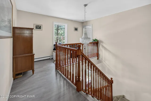 a view of a hallway with wooden floor and stairs