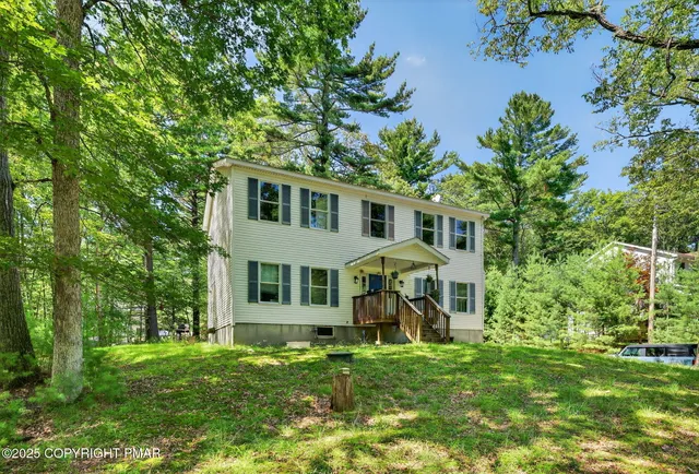 a view of a house with a yard and sitting area