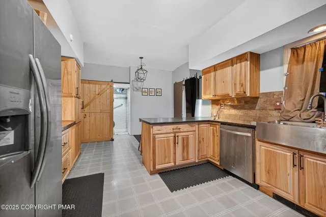 a large kitchen with stainless steel appliances granite countertop a refrigerator and a sink