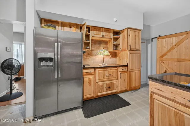 a kitchen with stainless steel appliances granite countertop a refrigerator and a stove top oven