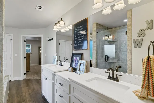 a bathroom with double vanity and a mirror
