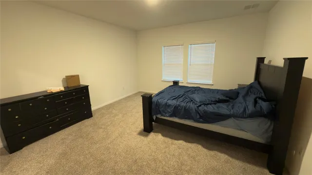 a bed sitting in a bedroom next to a window