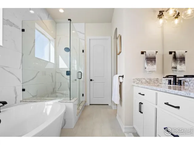 a bathroom with a granite countertop sink a shower a mirror and a bathtub