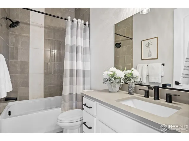 a bathroom with a granite countertop sink a toilet and shower