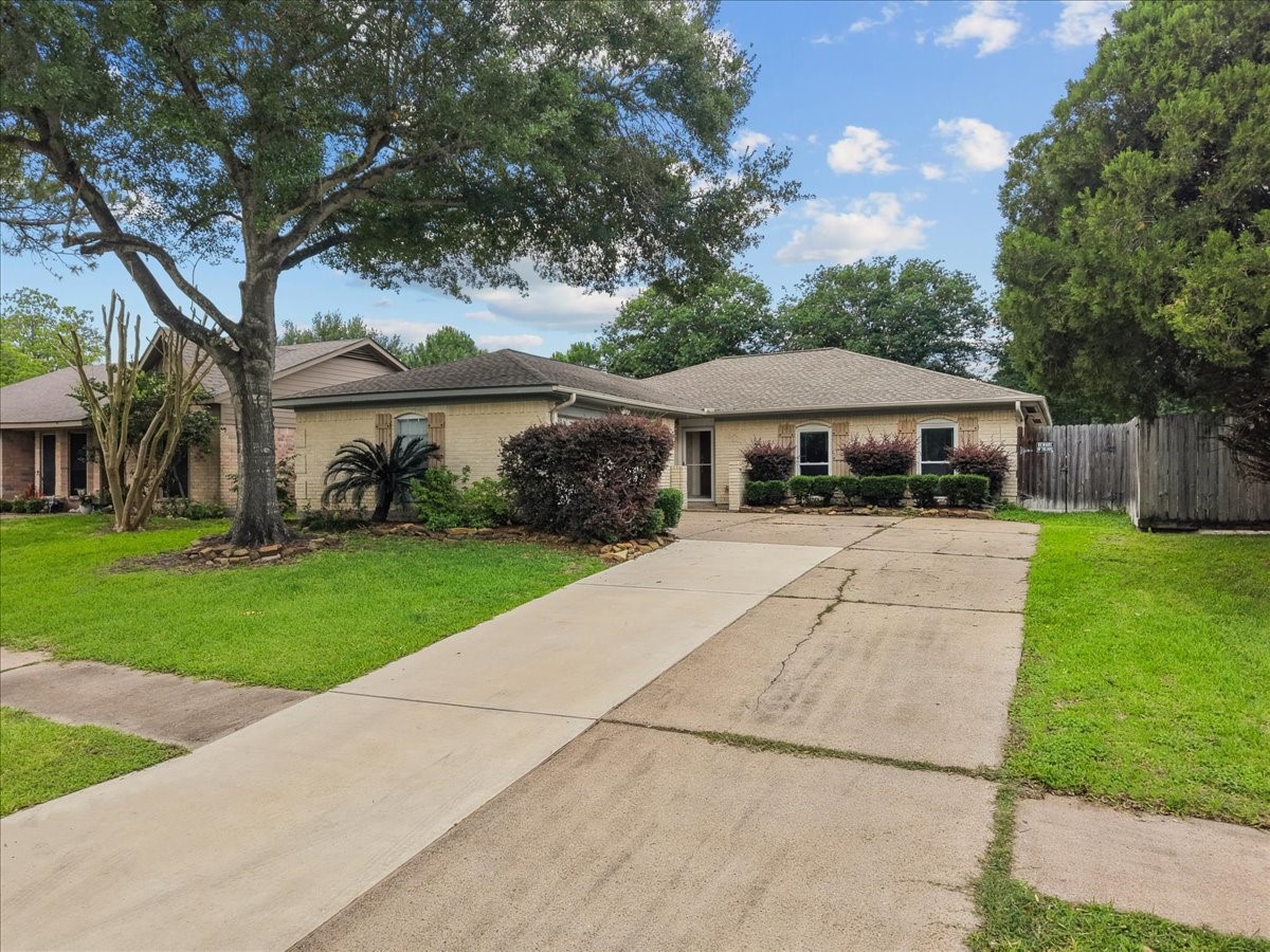 883 Silverpines Road Houston, TX 77062 - Photo 2 of 38 Charming single-story home with a well-maintained lawn and landscaping. Features a spacious driveway, mature trees, and a cozy front porch. Ideal for comfortable living in a serene neighborhood setting.