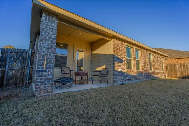 a backyard of a house with table and chairs