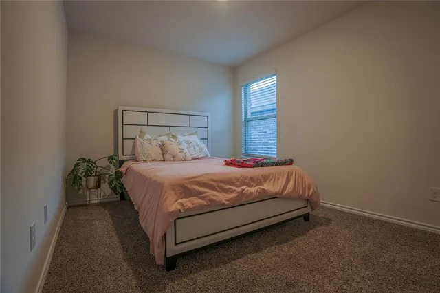 a bed sitting in a bedroom next to a window