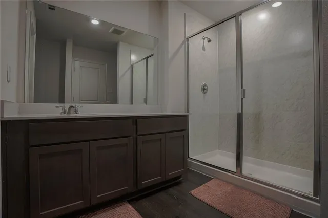 a bathroom with a shower sink and mirror