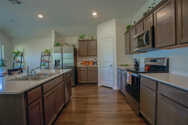 a kitchen with stainless steel appliances a sink stove and cabinets